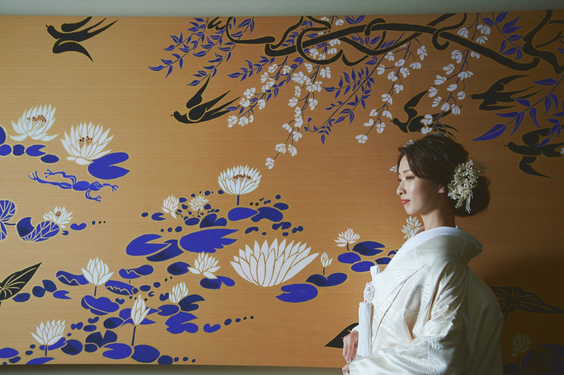 披露宴：金彩の壁画を背にした花嫁
